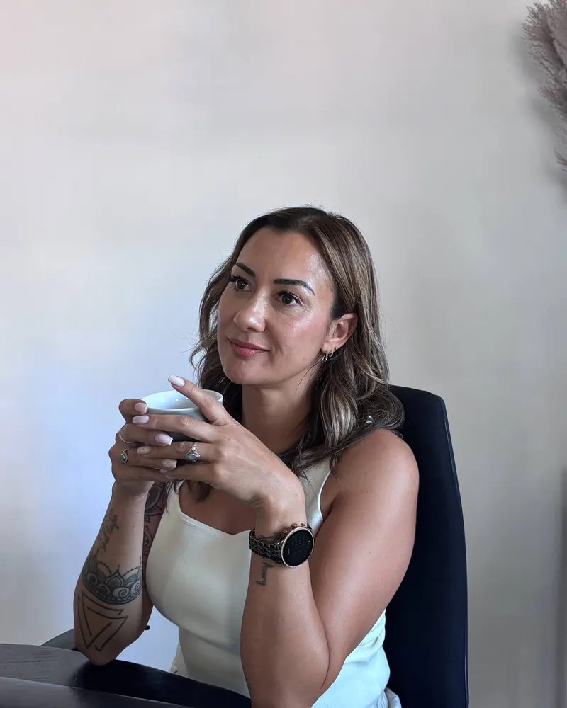 Jordana kijkt met een kop koffie in haar handen opzij